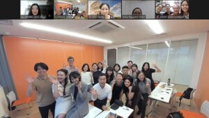 Winkende TN auf der Nachwuchskonferenz in Tokio mit Zoomeinbettung